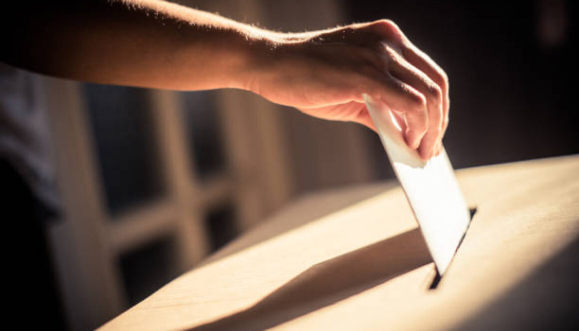 Imagen conceptual de una persona votando, depositando su papeleta en un colegio electoral durante unas elecciones.